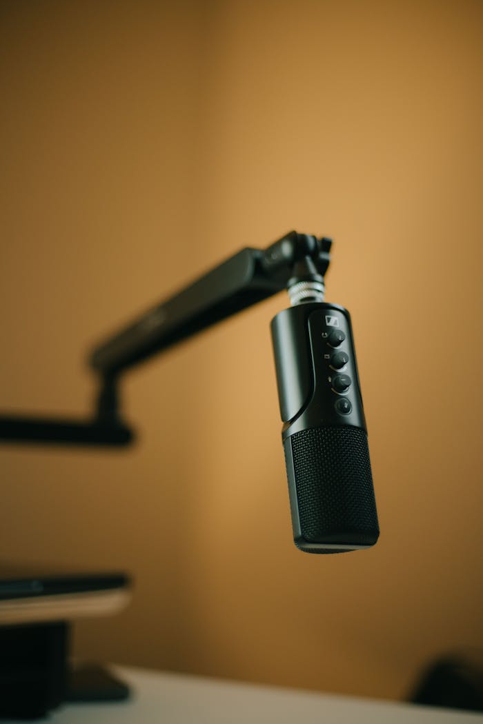 Close-up of a professional microphone on an adjustable arm, ideal for podcasting or broadcasting setups.