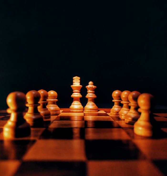 Wooden chess pieces on a board, emphasizing strategy and tactics against a dark background.
